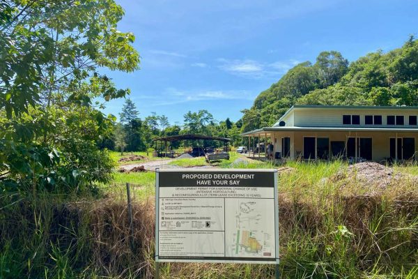 View from front gate showing development application sign, old hangar and house
